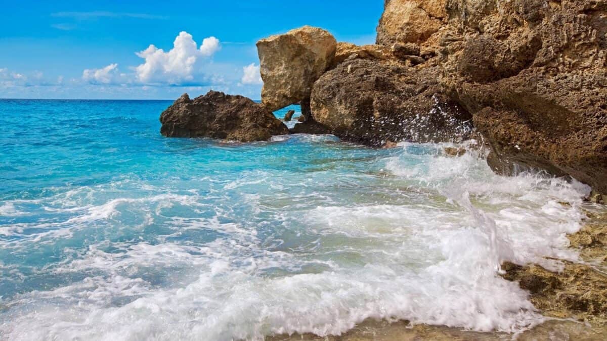 Bild zeigt einen Küstenstreifen mit türkisfarbenem Meer.